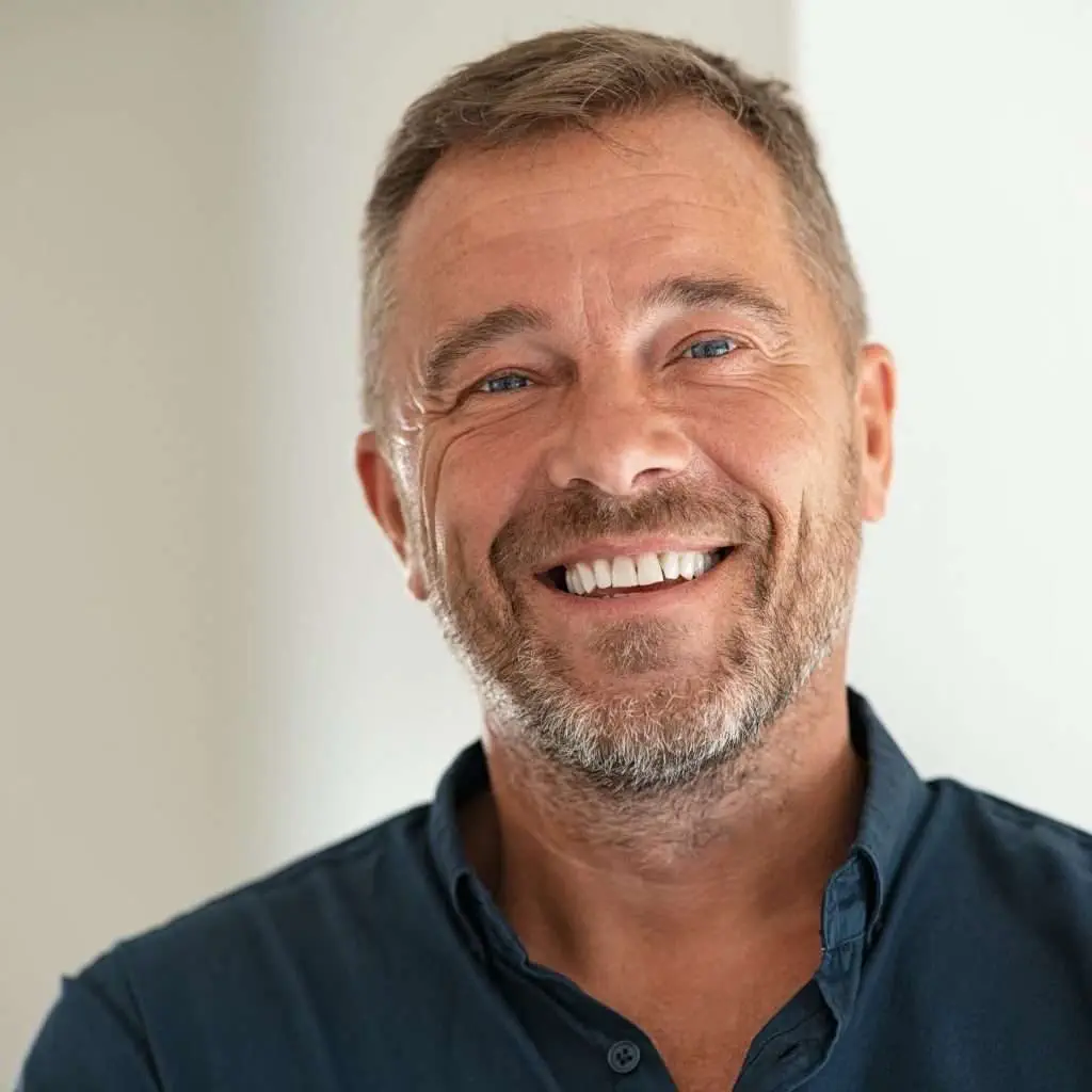 Handsome businessman smiling and looking at camera. Portrait of carefree mature man with copy space. Successful mid adult business man laughing.